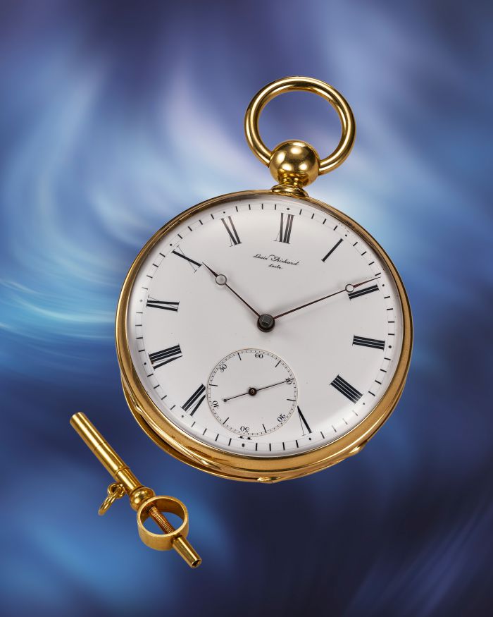 Orologio da tasca dorato con quadrante bianco, numeri romani neri e lancette sottili, con chiave di carica.