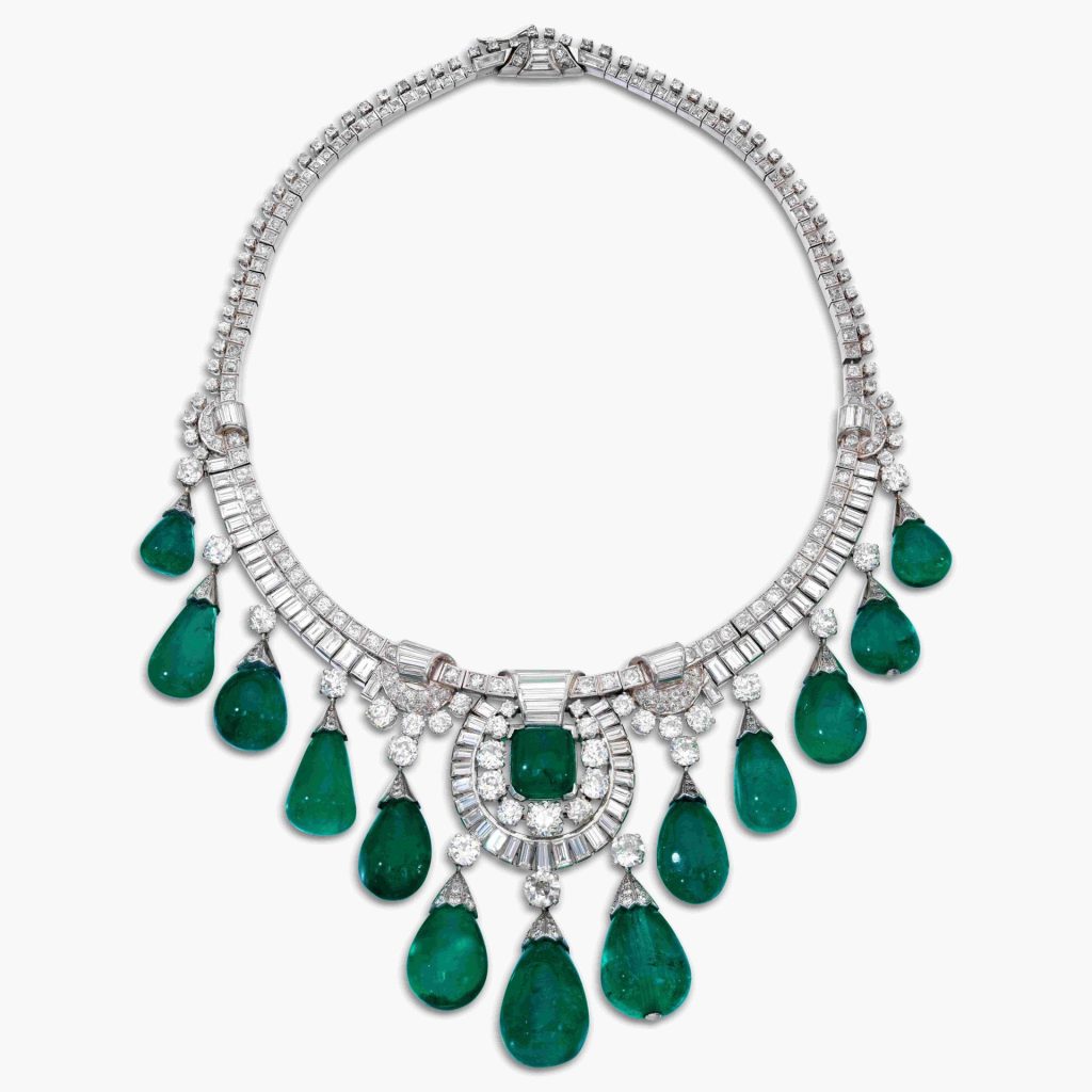 Collier di diamanti e smeraldi a forma di goccia, su sfondo bianco. Gioiello lussuoso e scintillante.