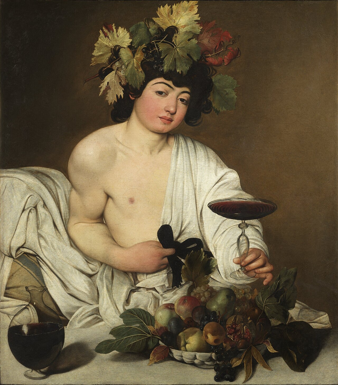 Giovane con corona di foglie e uva, tiene un bicchiere di vino rosso. Cesto di frutta.