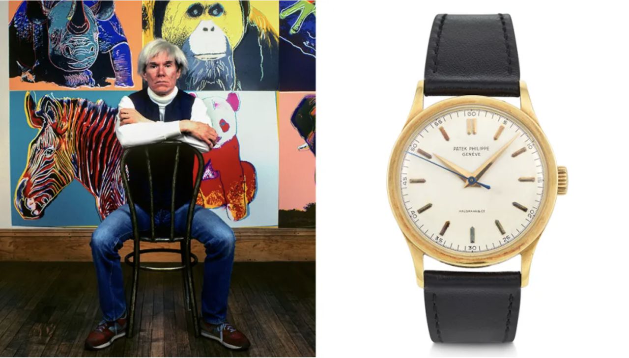 Andy Warhol seduto su una sedia davanti a sue opere, e un orologio Patek Philippe con cinturino nero.