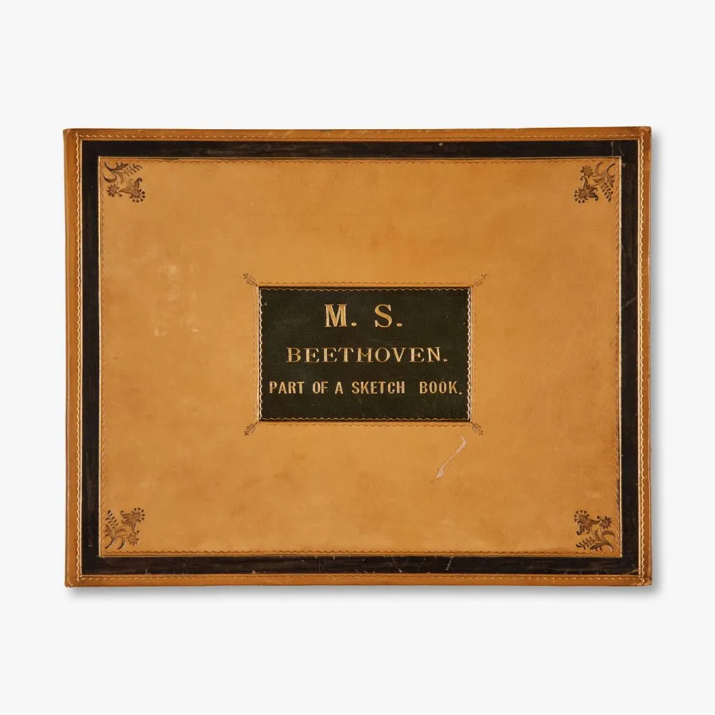 Copertina di un quaderno di schizzi di Beethoven, con decorazioni floreali agli angoli e scritte in oro.