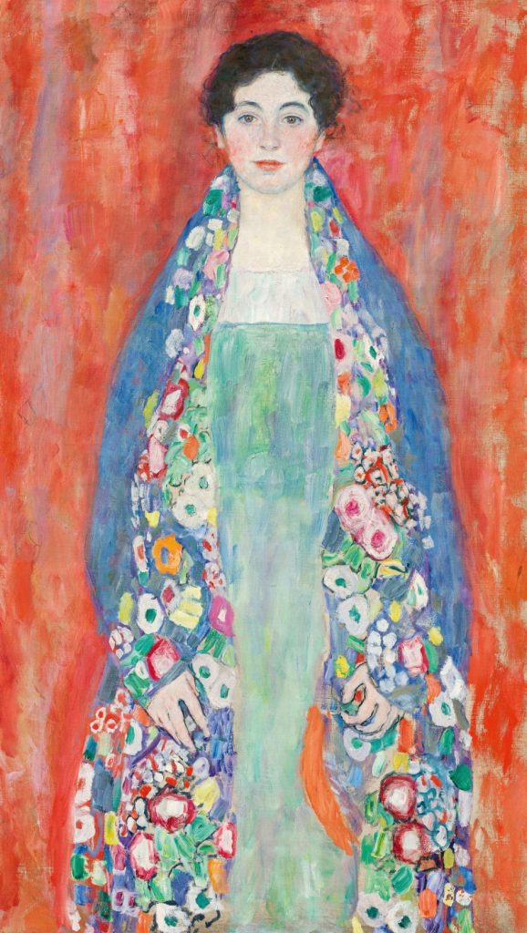 Ritratto di donna con scialle fiorito su sfondo rosso.