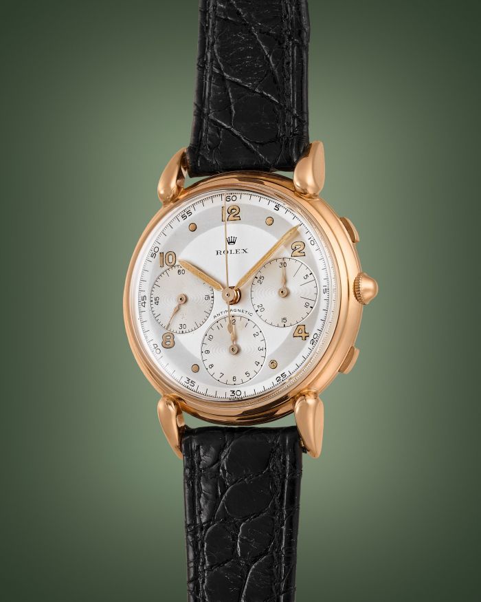Orologio da polso Rolex in oro rosa con quadrante bianco, cinturino in pelle nera.