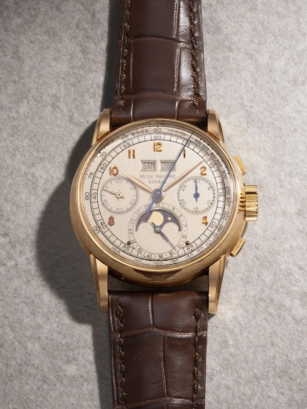 Orologio Patek Philippe in oro con cinturino in pelle marrone, quadrante avorio con indicatore fasi lunari.