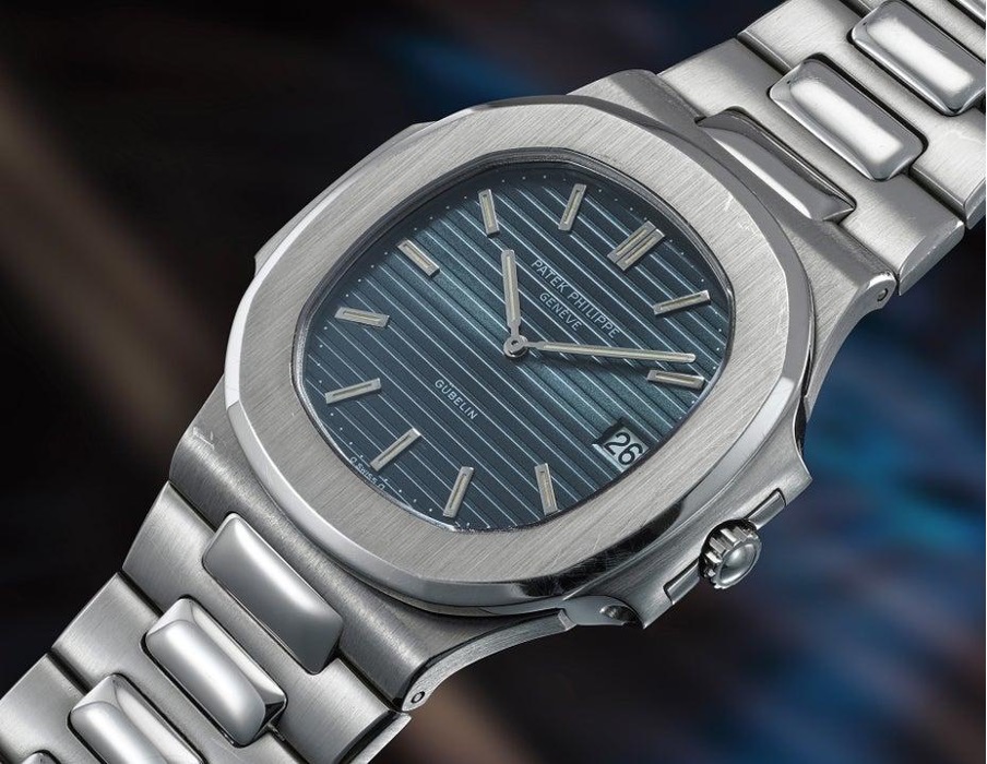 Orologio da polso Patek Philippe con quadrante blu a righe, datario e bracciale in metallo.