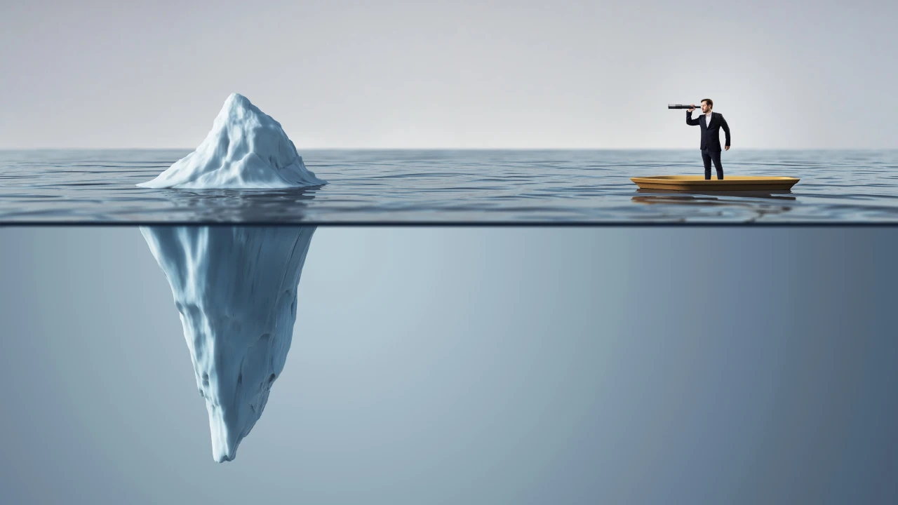 Uomo in barca guarda iceberg con binocolo. Sott'acqua, la maggior parte dell'iceberg è visibile.