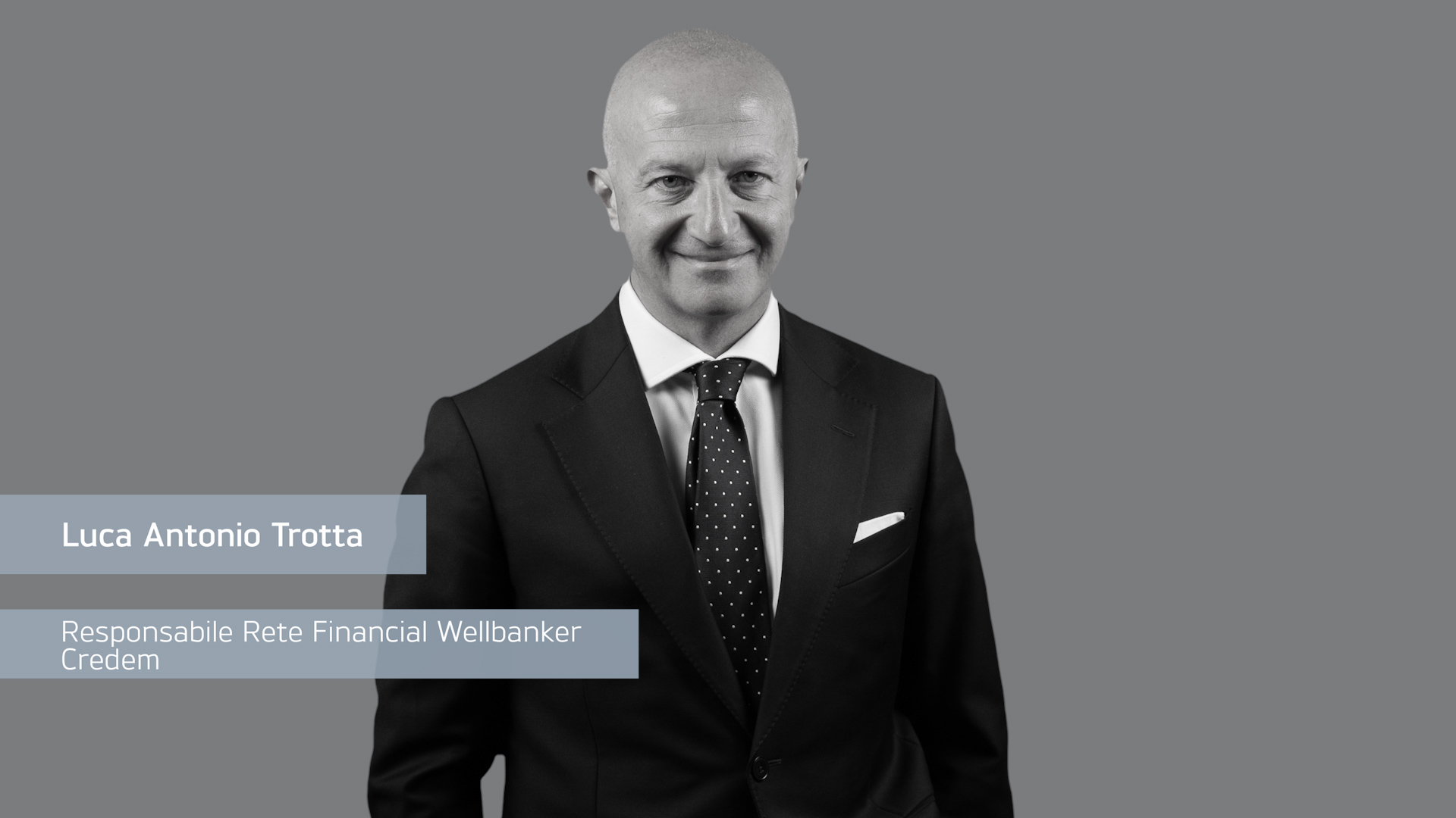 Uomo con abito scuro, cravatta a pois, sorride. Testo: Luca Antonio Trotta, Responsabile Rete Financial Wellbanker Credem.