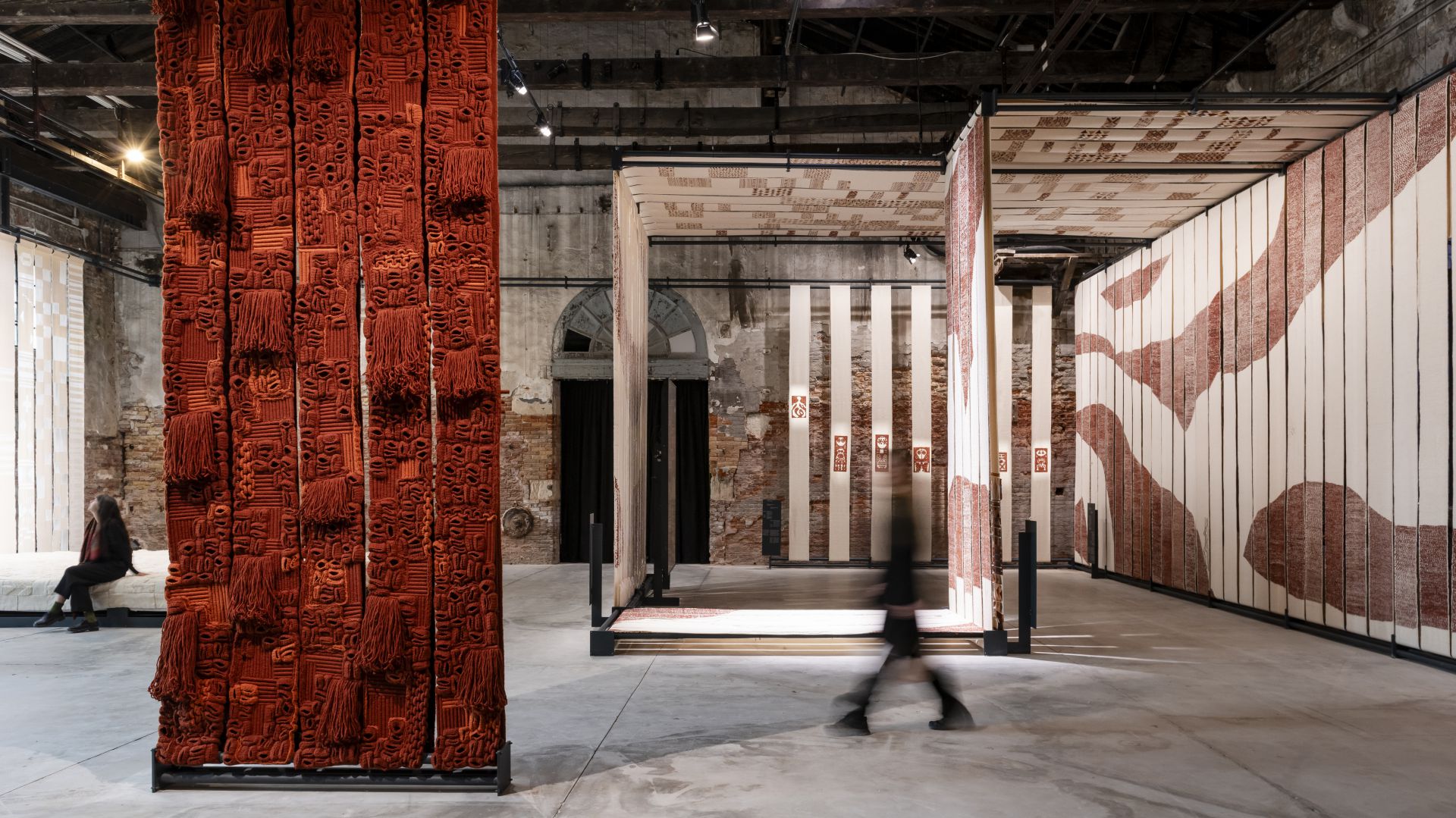 Tessuti rossi e bianchi decorano pareti e soffitti di un'installazione artistica.