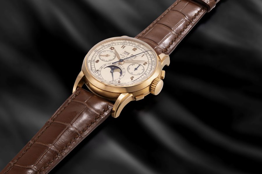 Orologio da polso in oro giallo con cinturino in pelle marrone e quadrante con fasi lunari.