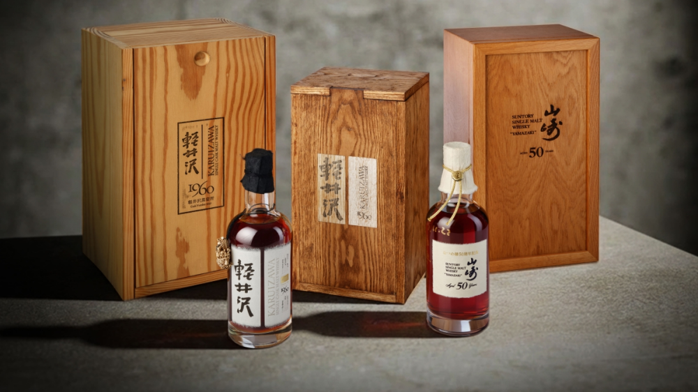 Tre bottiglie di whisky in confezioni di legno, con etichette scritte in giapponese.