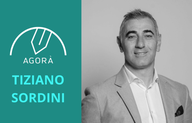 Uomo sorridente in giacca e camicia, con logo e nome "Tiziano Sordini".