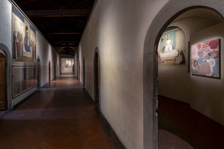 Corridoio con affreschi antichi e un quadro moderno, pavimentazione in cotto.