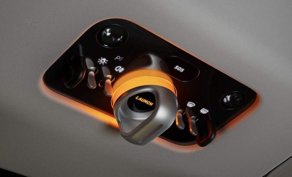 Pulsante "LAUNCH" illuminato, controlli luci, SOS e tergicristalli su pannello nero con retroilluminazione arancione.