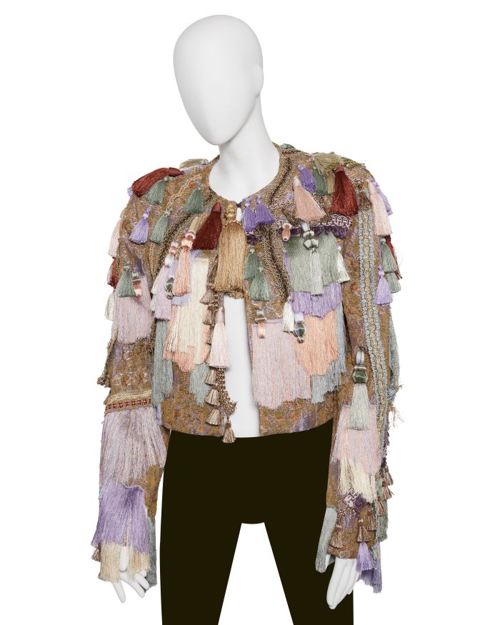 Giacca colorata con frange e nappe su un manichino.