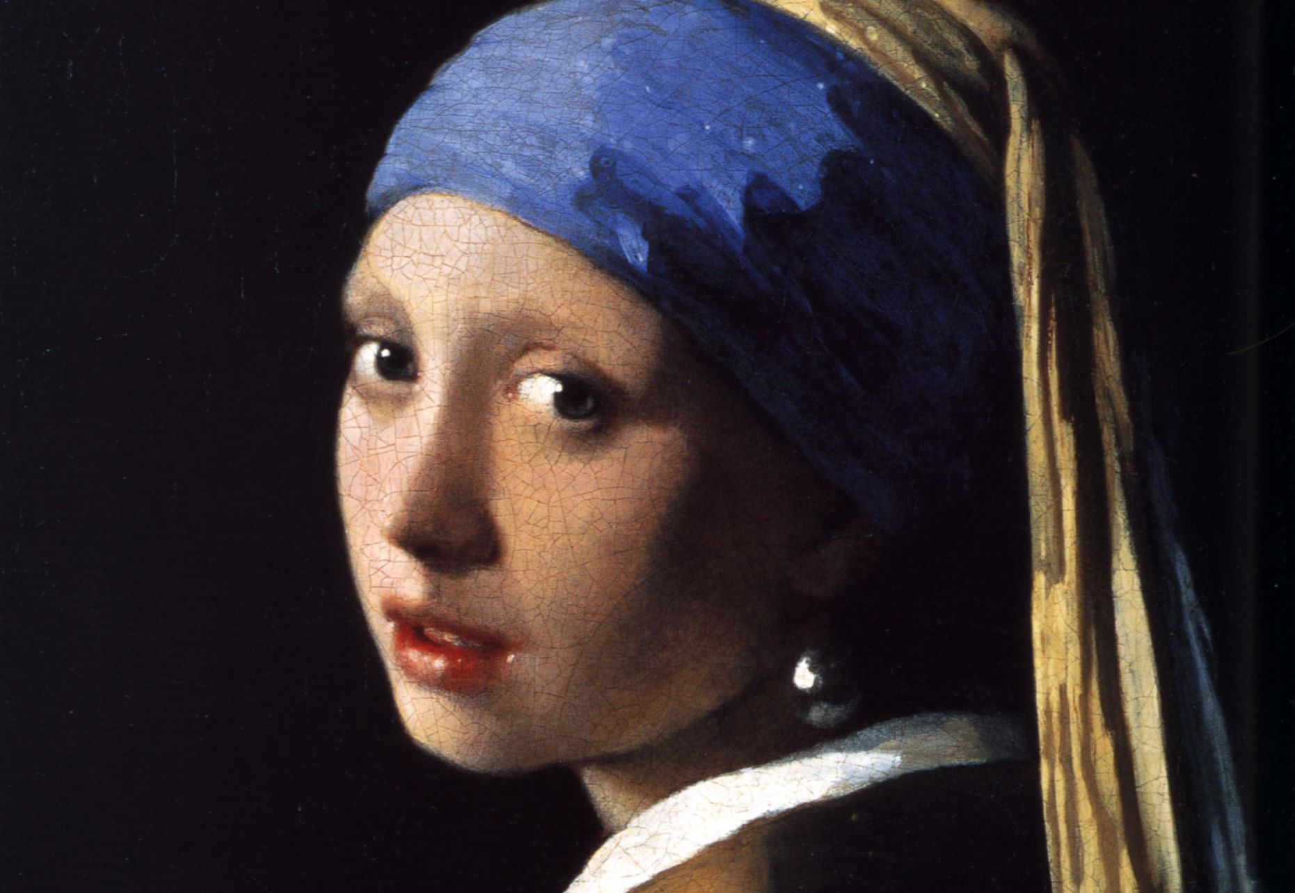 Ragazza con turbante blu e perla, guarda di profilo con labbra rosse.