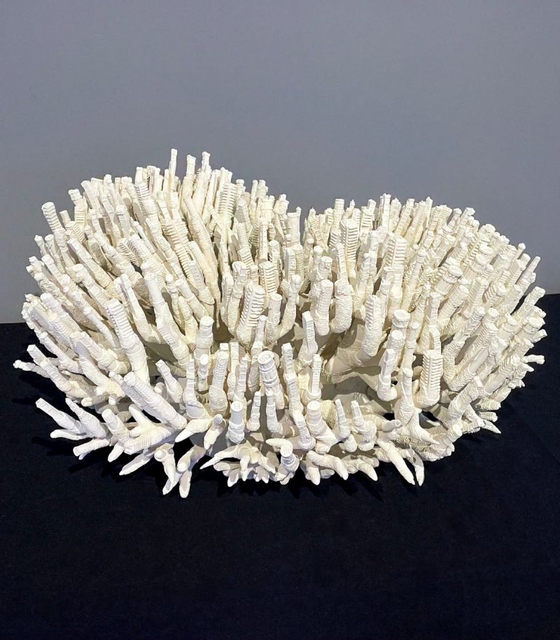 Scultura bianca simile a corallo, con molti piccoli cilindri e ramificazioni.
