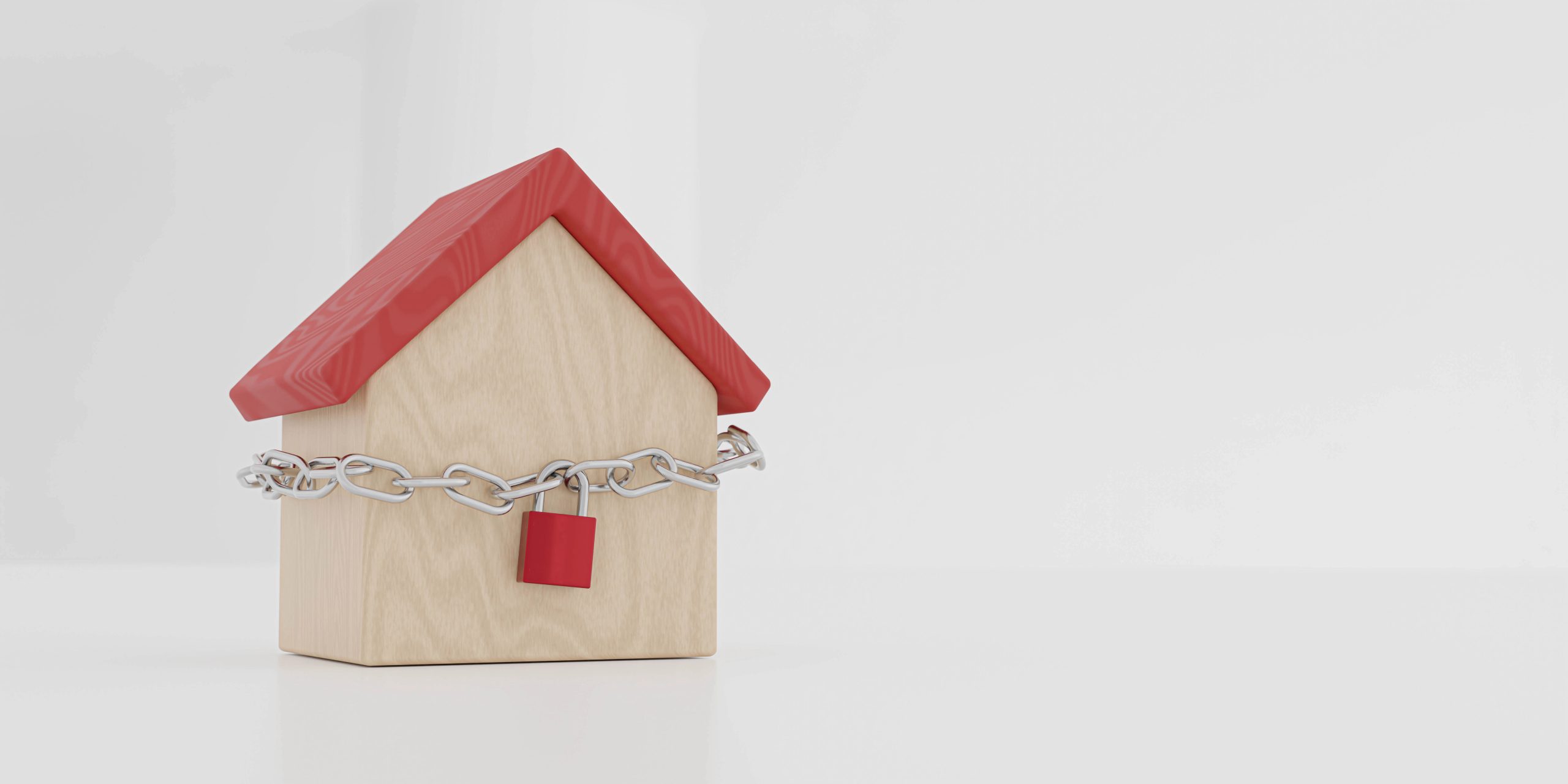Casa di legno con tetto rosso, chiusa da una catena e un lucchetto rosso.