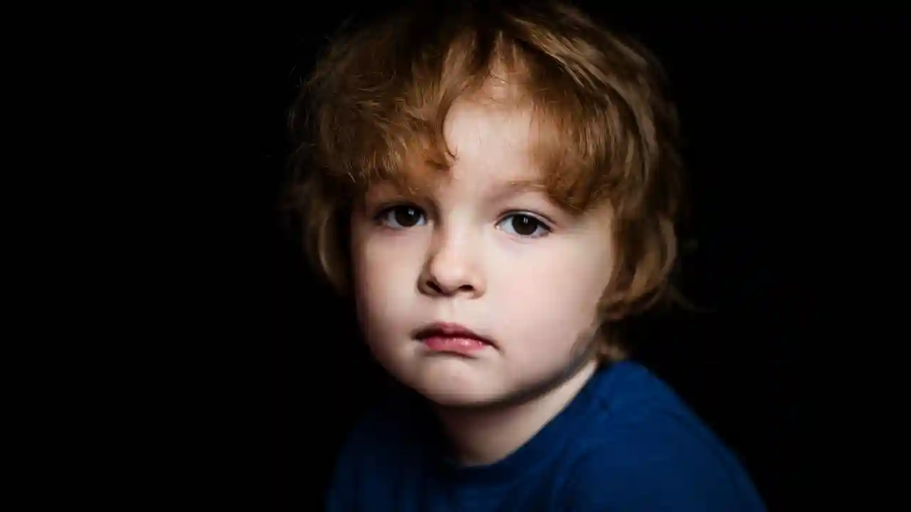 Bambino con capelli castani e occhi scuri, indossa una maglietta blu.