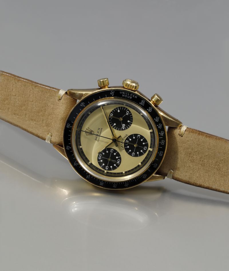 Orologio da polso Rolex Daytona in oro giallo con cinturino in pelle chiara.