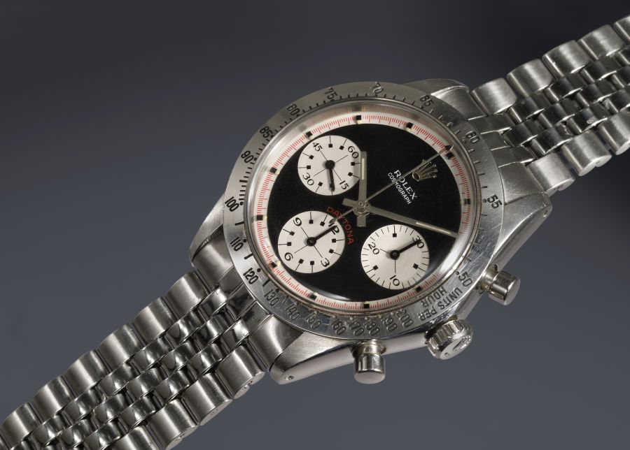 Orologio Rolex Daytona con quadrante nero, tre contatori bianchi e cinturino in metallo.