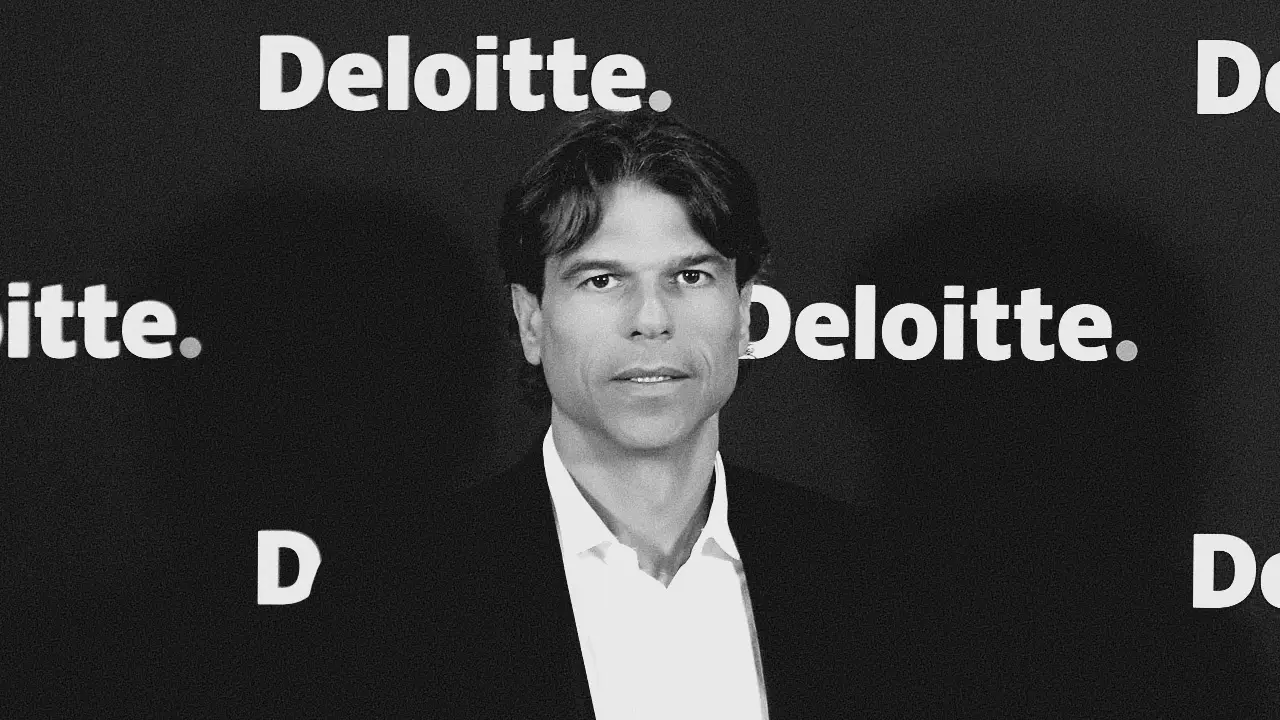 Uomo in giacca e camicia bianca, sullo sfondo il logo Deloitte.