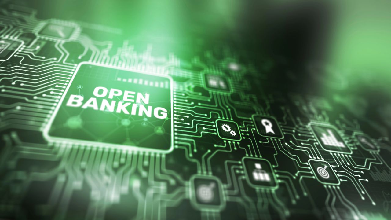 Circuito stampato verde con testo "OPEN BANKING" e icone di servizi finanziari.