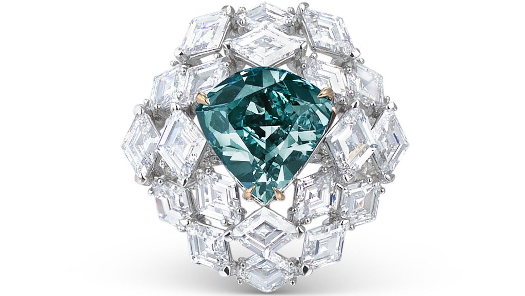 Anello con grande gemma blu-verde a forma di pera, circondato da diamanti bianchi a taglio quadrato.