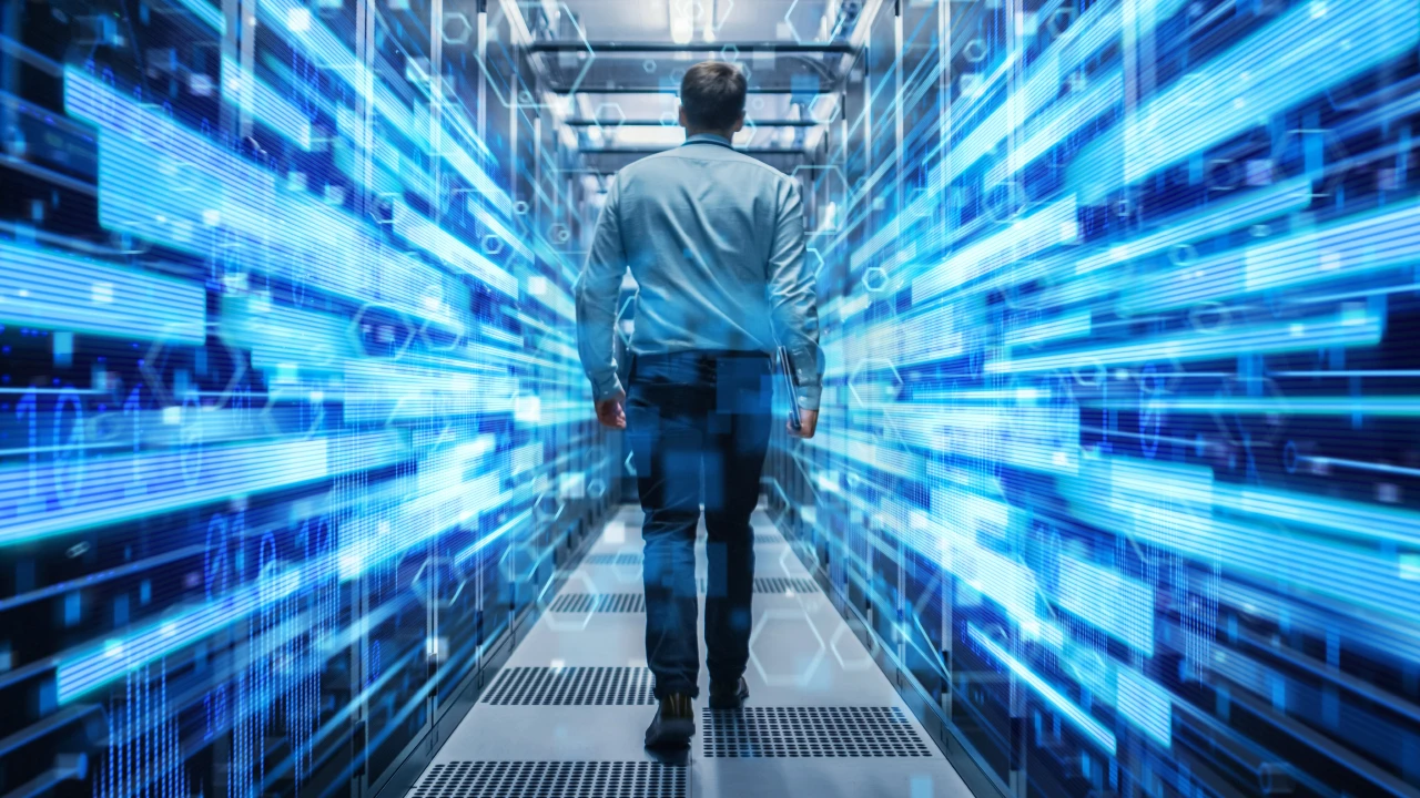 Uomo cammina in un corridoio di data center con luci blu astratte e dati digitali.