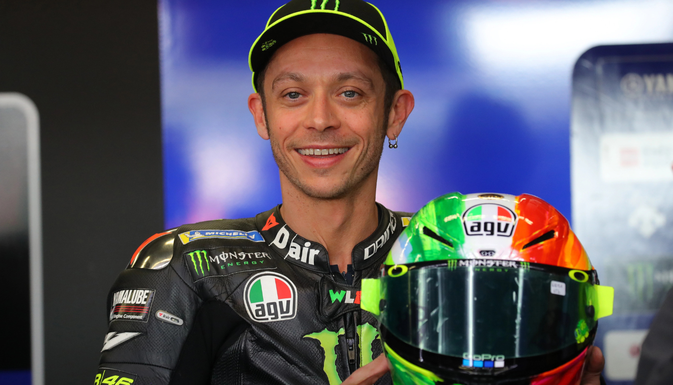 Valentino Rossi in tuta da gara con casco, protagonista dell’articolo sul suo patrimonio