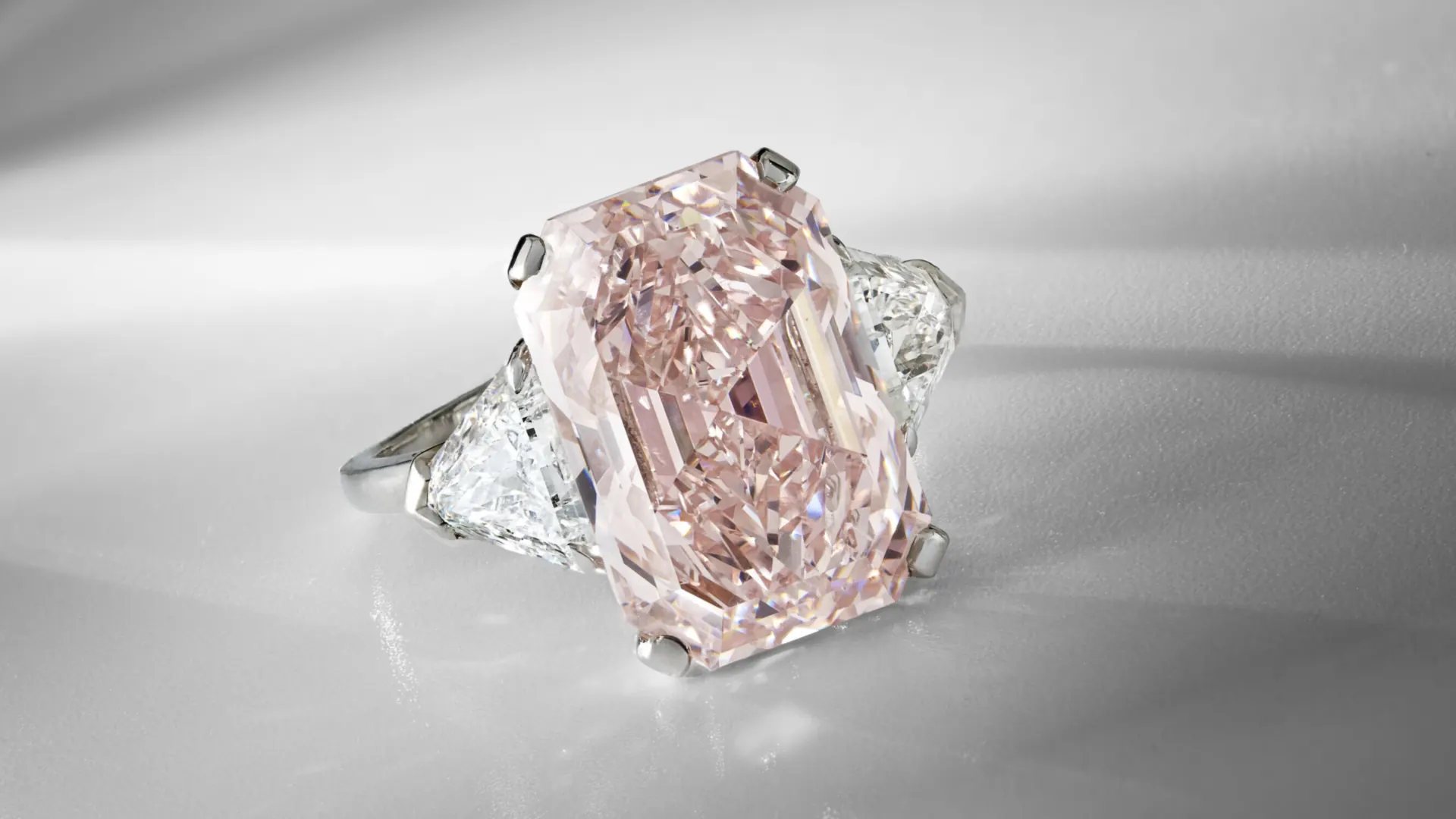 Anello con grande diamante rosa rettangolare affiancato da due diamanti triangolari nell'asta di gioielli di Christie's Ginevra.
