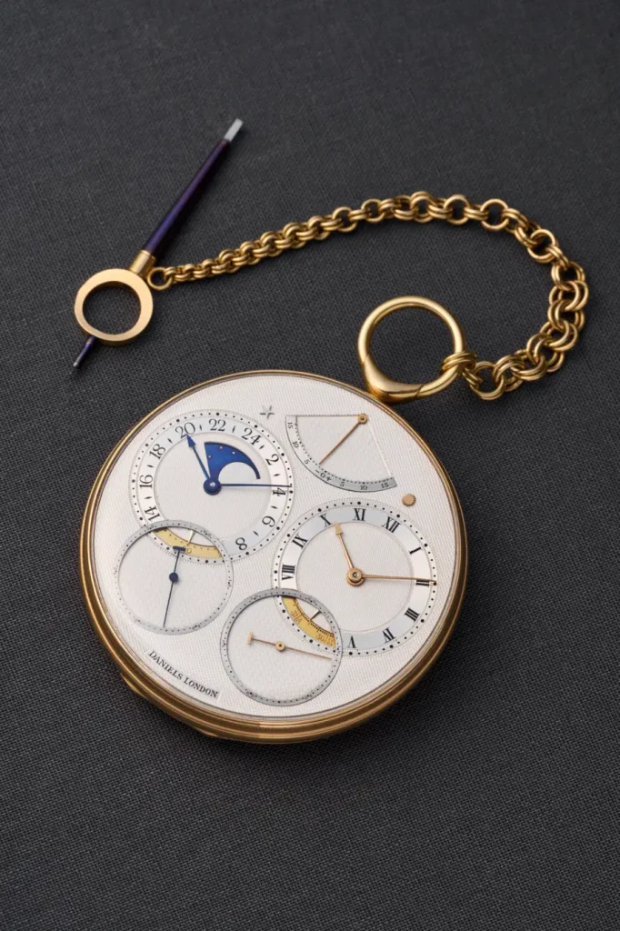 Orologio da tasca con quadrante multiplo, catena dorata e anello con puntale blu, è uno George Daniels Space Traveller