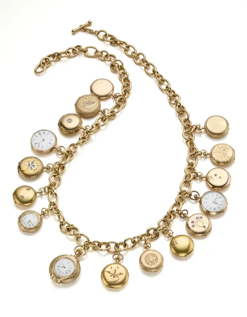 Collana d'oro con ciondoli a forma di orologi e medaglioni, alcuni decorati.