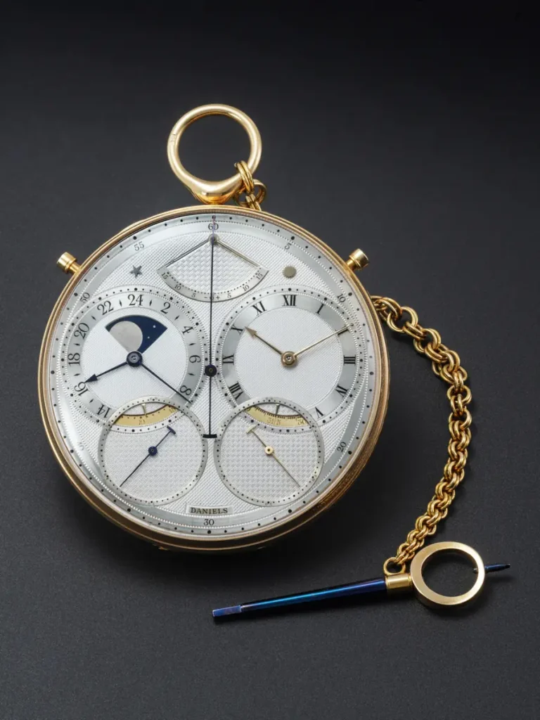 Orologio da tasca con quadrante multiplo, catena dorata e anello con puntale blu, è uno George Daniels Space Traveller