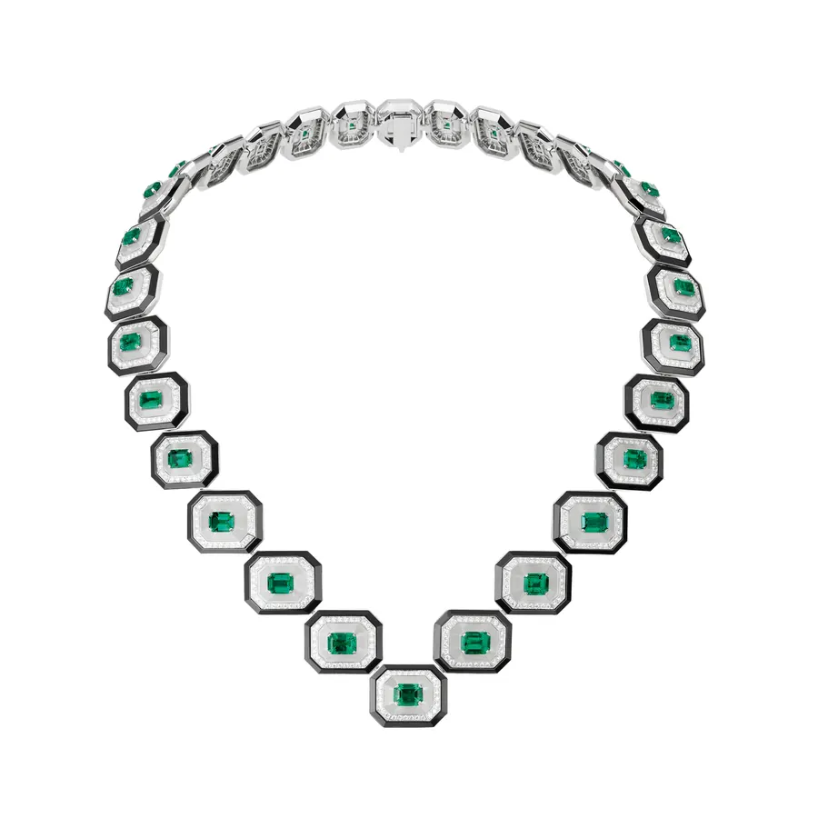 Collana con smeraldi rettangolari, diamanti e dettagli neri su sfondo bianco.