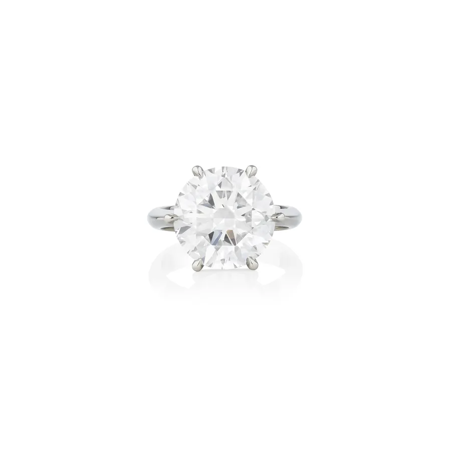 Anello con grande diamante rotondo a sei griffes su sfondo bianco.