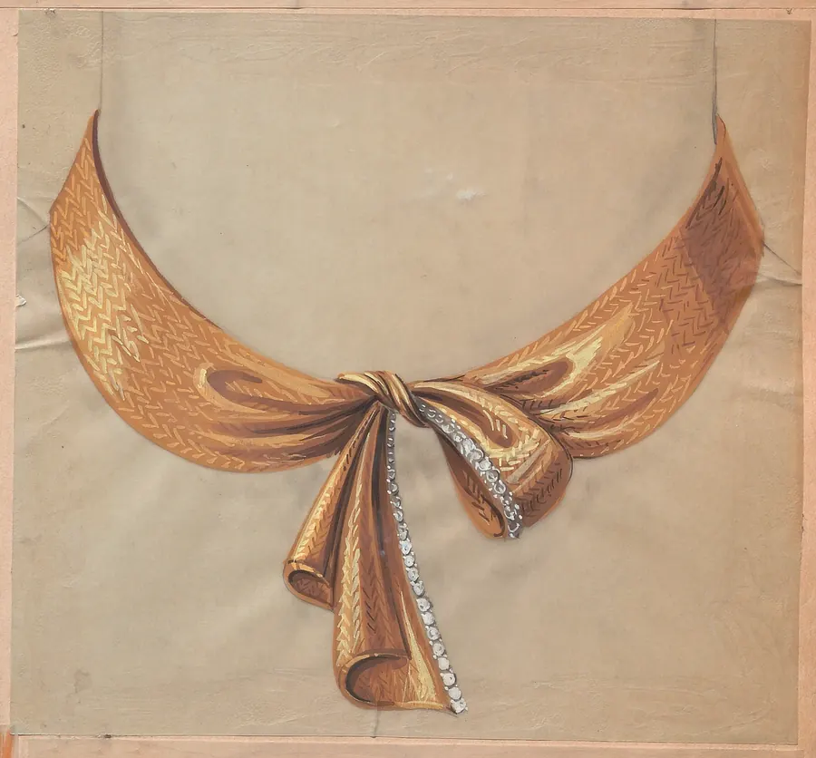 Collana dorata a forma di fiocco con dettagli di diamanti su sfondo beige.
