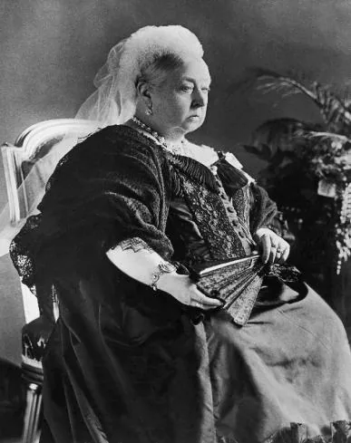 Regina Vittoria seduta, con ventaglio, velo e abito scuro.