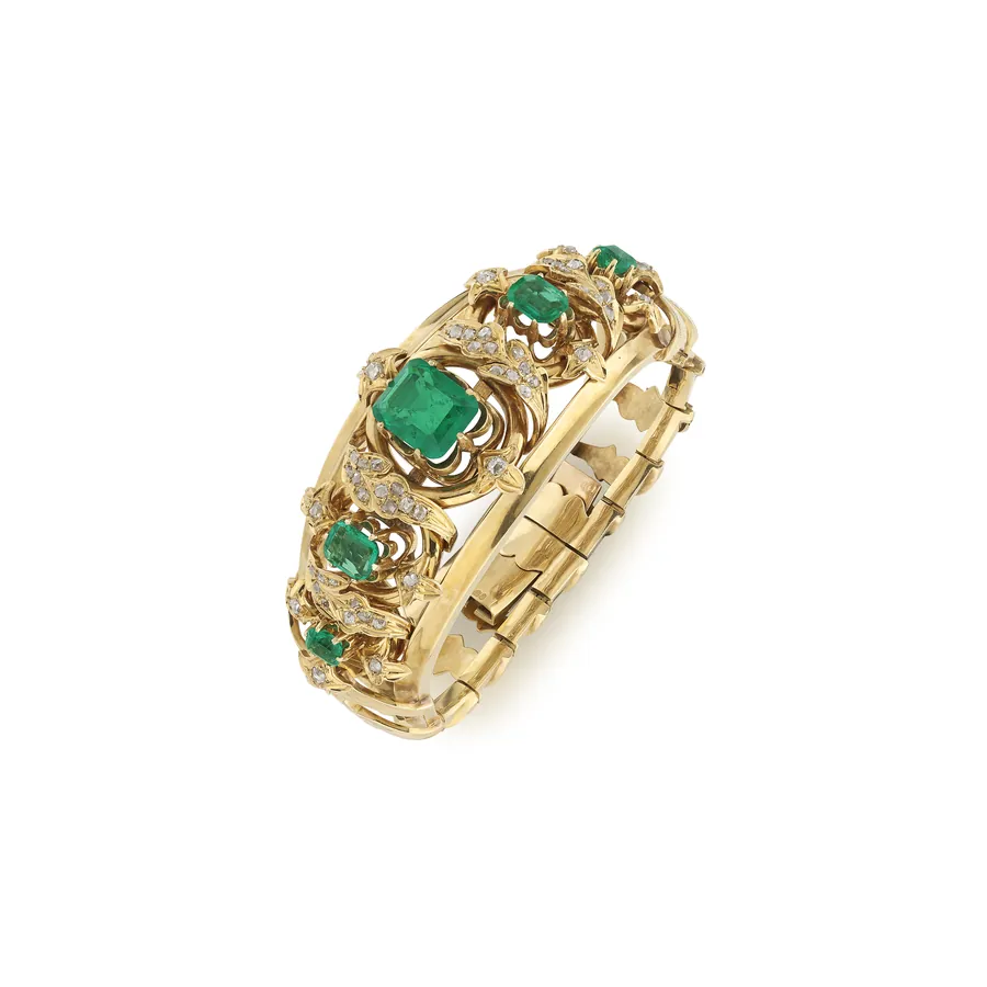 Bracciale in oro giallo con smeraldi centrali e diamanti incastonati in un design floreale.