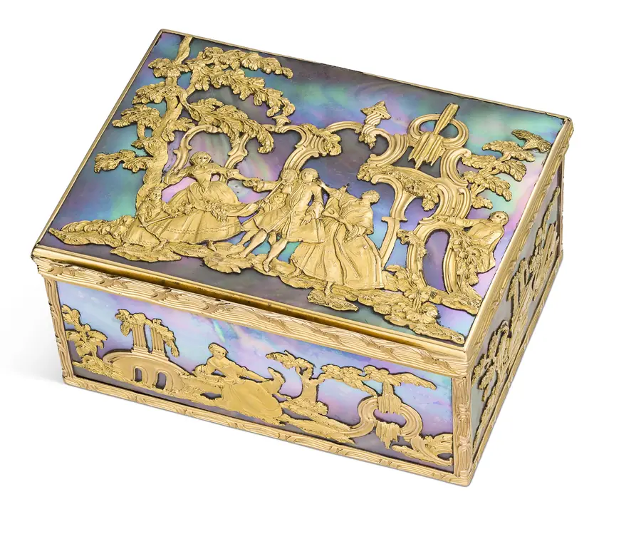 Scatola rettangolare con madreperla iridescente e decorazioni dorate di figure e paesaggi.