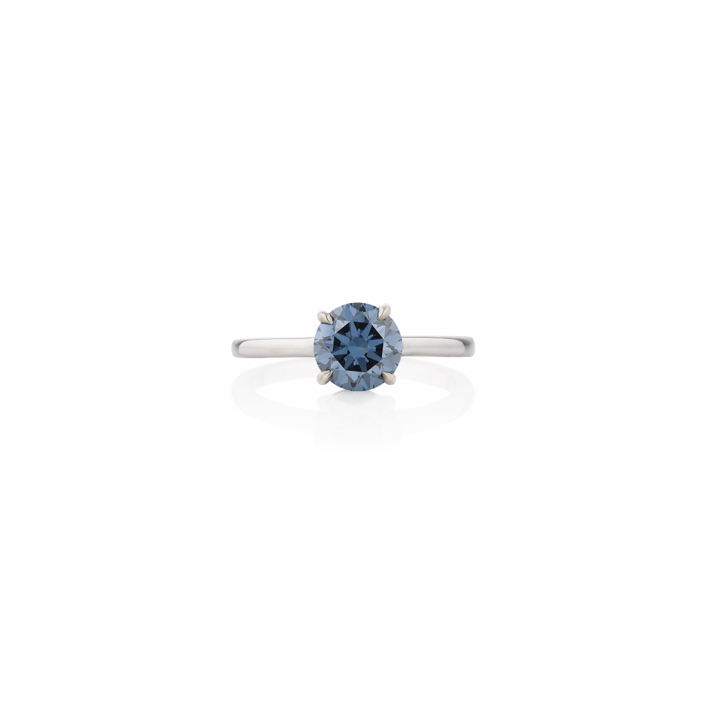 Anello con diamante blu rotondo sfaccettato su montatura in oro bianco.