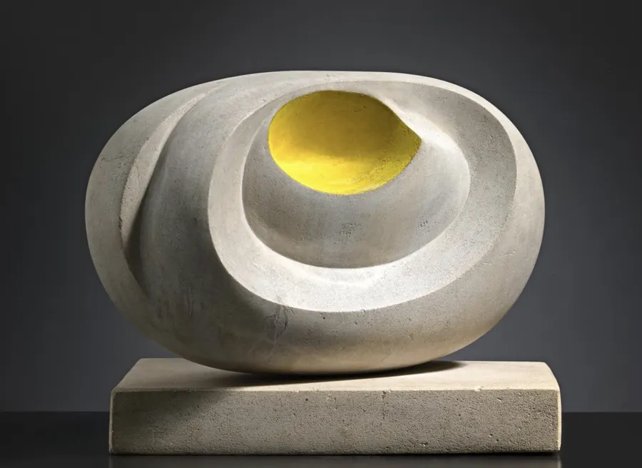 Scultura astratta in pietra chiara con un'apertura interna di colore giallo brillante.