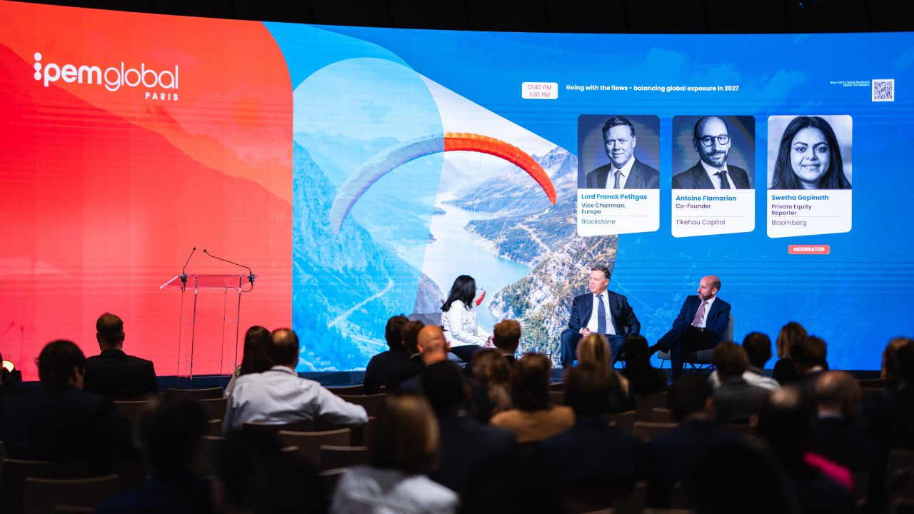 Panel di relatori con sfondo di paesaggio montano e parapendio.