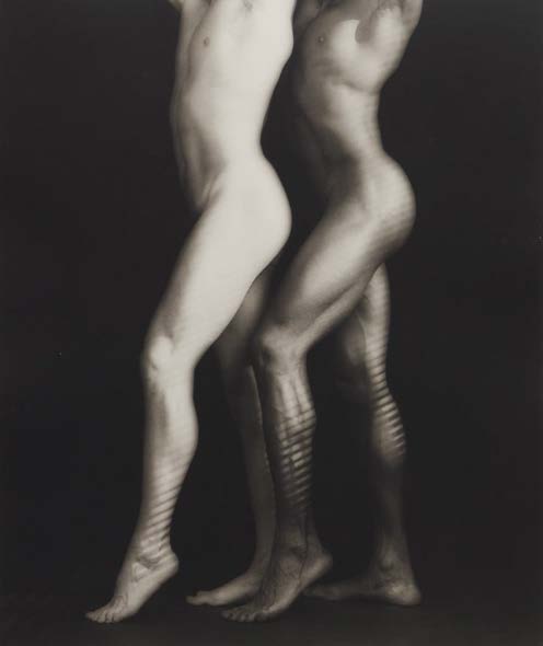 Due figure nude, una chiara e una scura, si intrecciano con ombre a strisce sulle gambe.