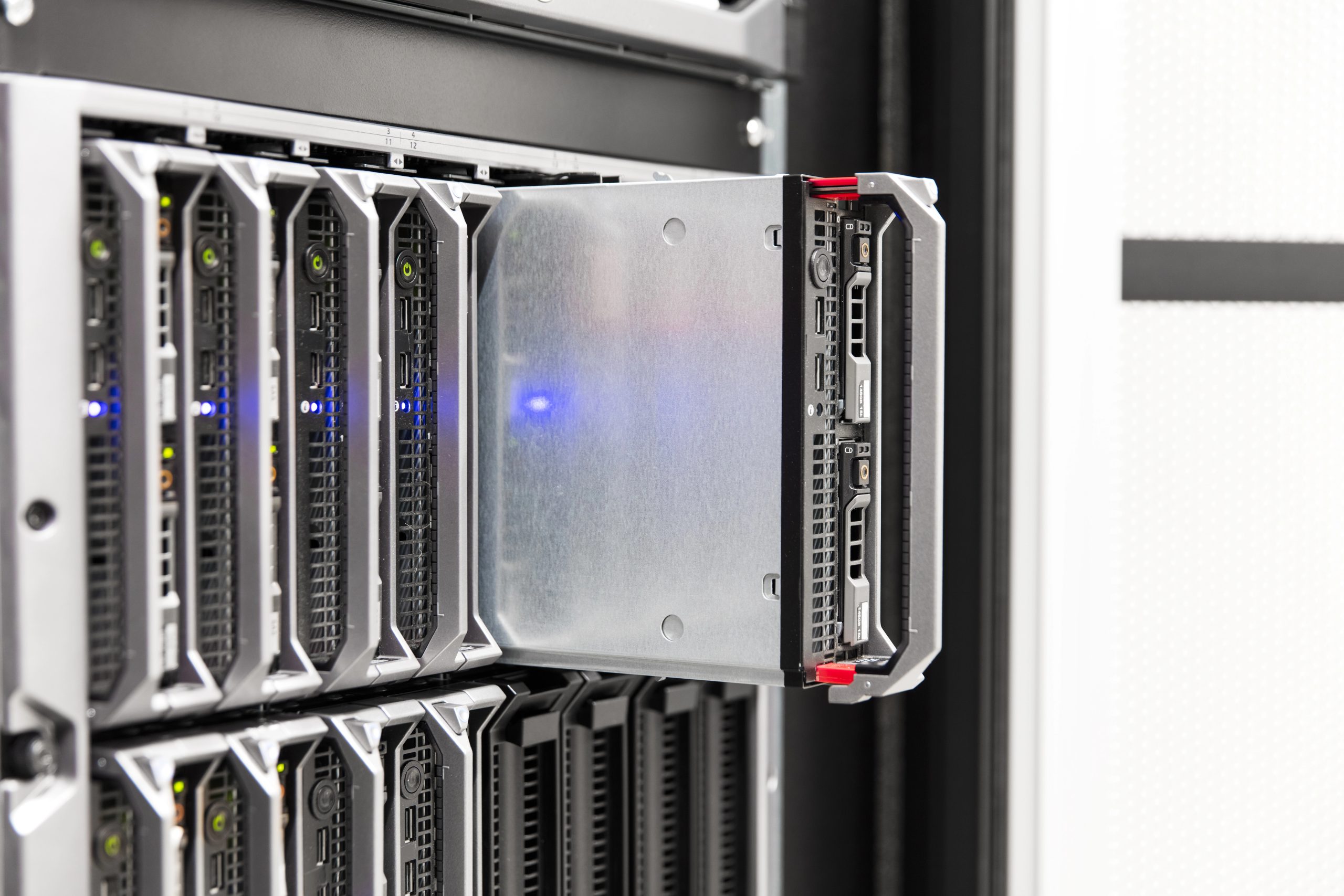 Server rack con unità estratta, luci blu e verdi accese, cavi visibili.
