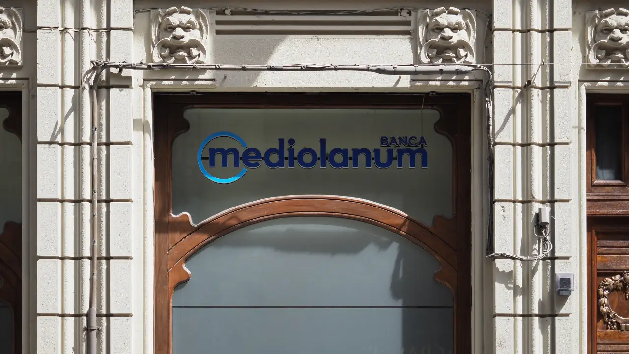 Logo Mediolanum Banca su una vetrata con cornice in legno e decorazioni architettoniche.
