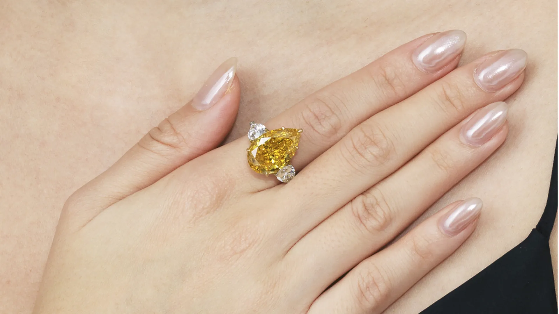 Anello con grande diamante giallo a goccia, fiancheggiato da diamanti più piccoli, è il Golden Flame di Christie's, scellto come esempio della valutazione diamanti di Auctentic
