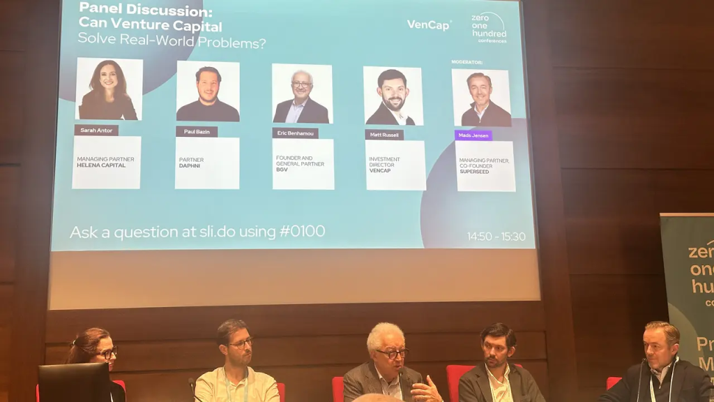Panel di discussione "Can Venture Capital Solve Real-World Problems?" con relatori e moderatore.