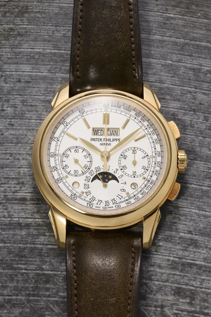 Patek Philippe da polso in oro giallo con quadrante bianco, datario, fasi lunari e cinturino in pelle marrone andrà in asta online da Phillips, con altri esemplari di pregio come Rolex.